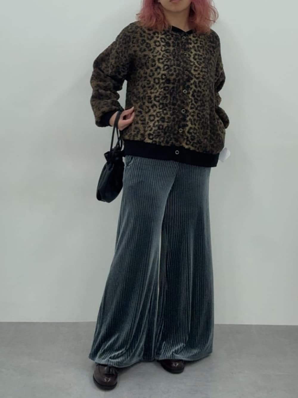 ブルー系のパンツ、ブラウン系のカーディガン/ボレロ、ブラウン系のスニーカーを着用したレディースの秋コーディネートの2枚目の写真