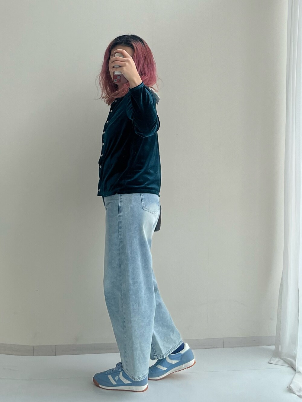 ブラック系のショルダーバッグ、ブルー系のパンツ、グリーン系のカーディガン/ボレロを着用したレディースの冬コーディネートの3枚目の写真