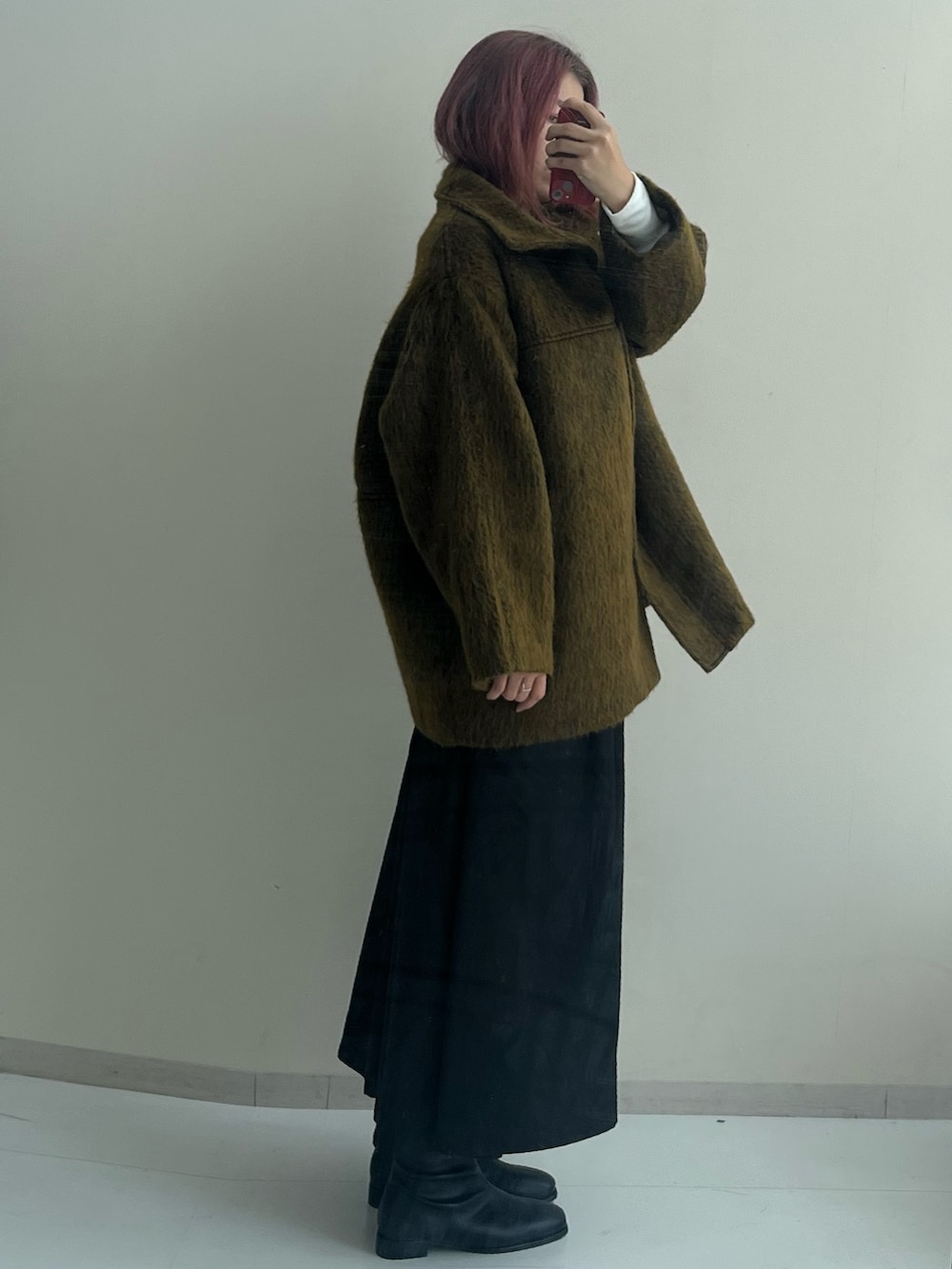 ブラック系のブーツ、ブラック系のスカート、イエロー系のジャケット/アウターを着用したレディースの秋コーディネートの4枚目の写真