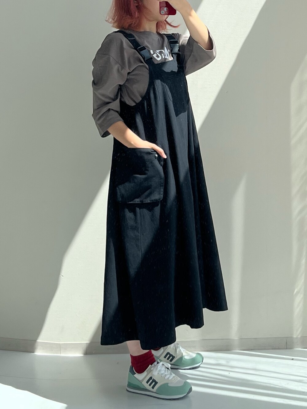 レッド系のスニーカー、ブラック系のワンピース、ブラック系のTシャツ/カットソーを着用したレディースの夏コーディネートの2枚目の写真