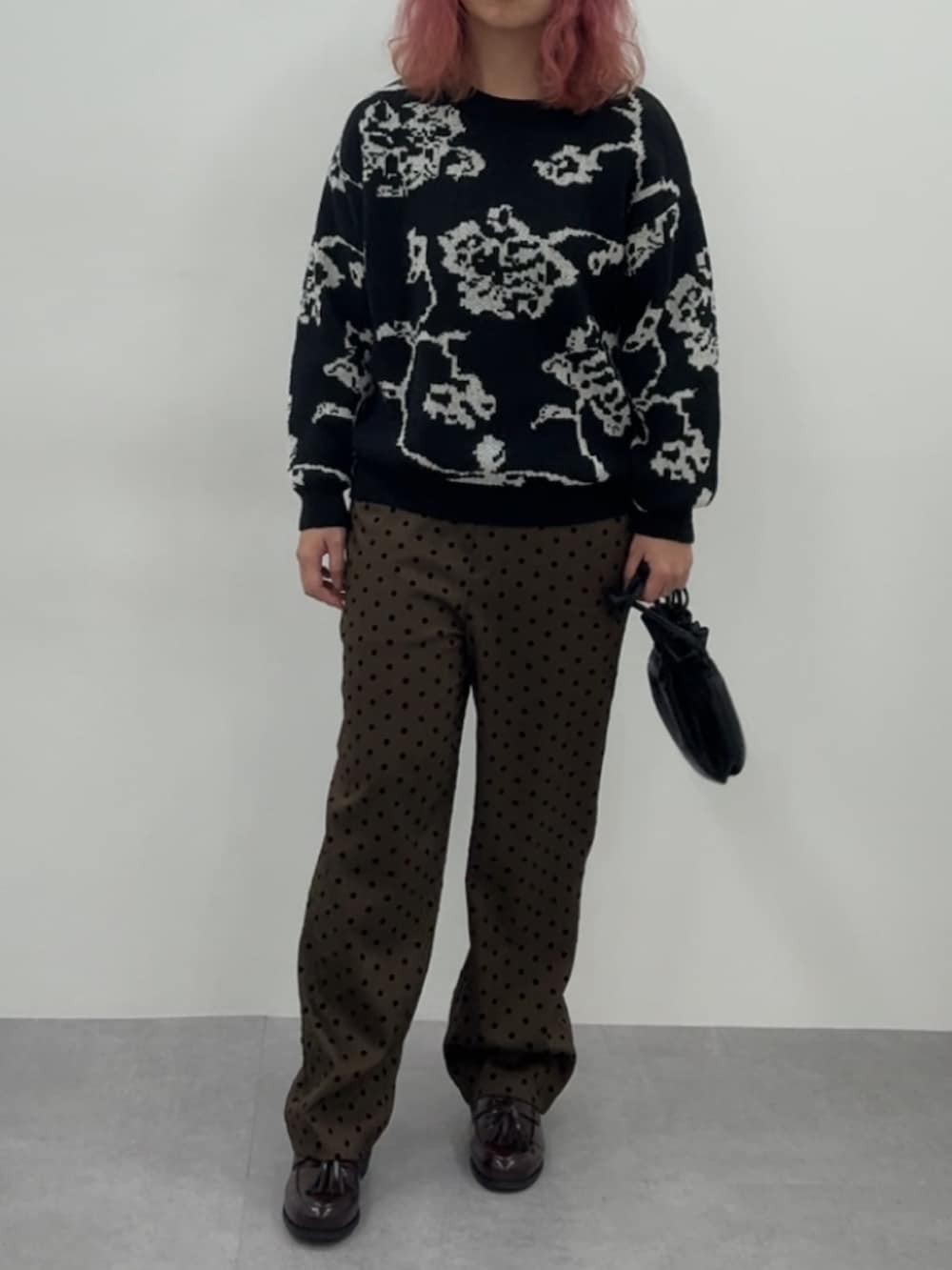 ブラウン系のスニーカー、ブラウン系のパンツ、ブラック系のニット/セーターを着用したレディースの冬コーディネートの2枚目の写真