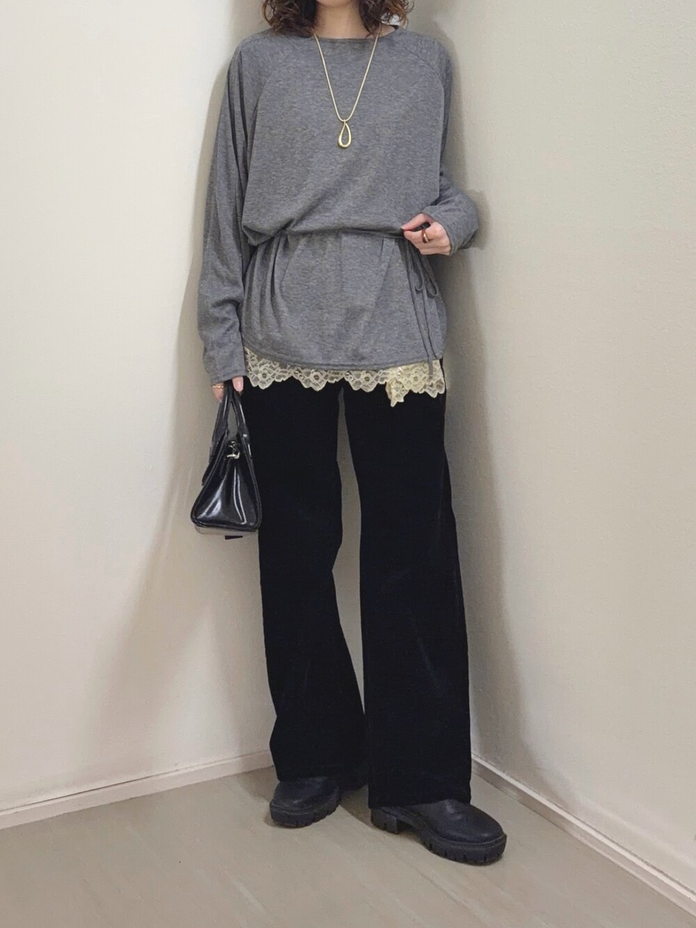 ベージュ系のキャミソール、ブラック系のデニムパンツ、ブラック系のボストンバッグを着用したレディースの冬コーディネートの5枚目の写真