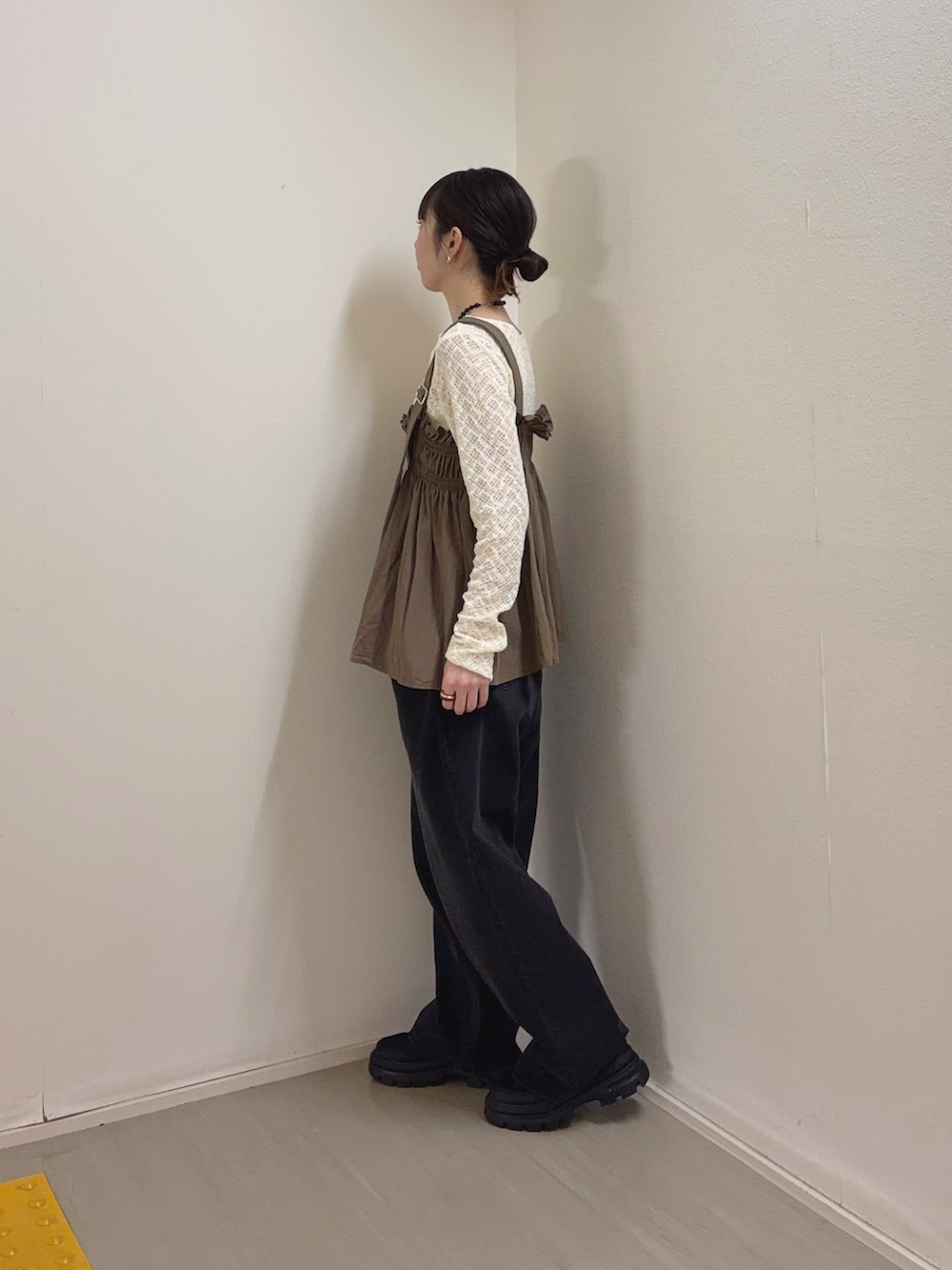 ブラック系のデニムパンツ、ブラック系のスニーカー、ホワイト系のTシャツ/カットソーを着用したレディースの春コーディネートの4枚目の写真