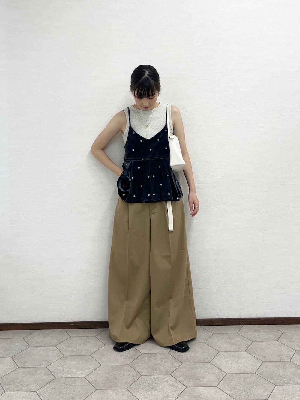 ベージュ系のタンクトップ、グレー系のキャミソール、ホワイト系のショルダーバッグを着用したレディースの秋コーディネートの2枚目の写真