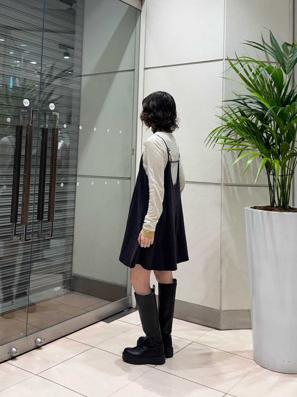 ブラック系のブーツ、グレー系のワンピース、ブラック系のショルダーバッグを着用したレディースの秋コーディネートの3枚目の写真