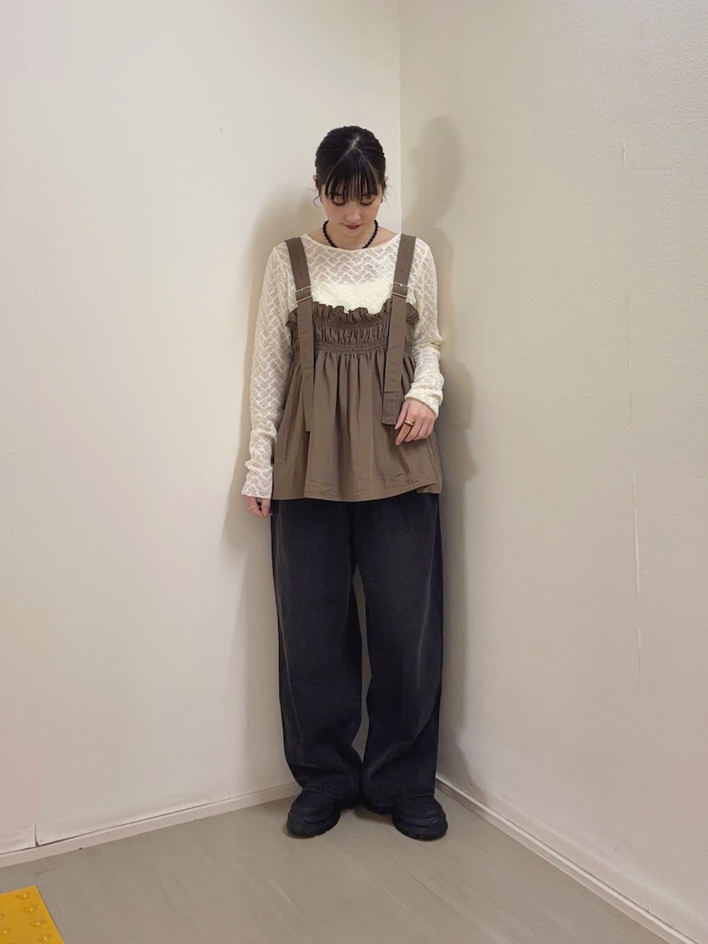 ブラック系のデニムパンツ、ブラック系のスニーカー、ホワイト系のTシャツ/カットソーを着用したレディースの春コーディネートの3枚目の写真