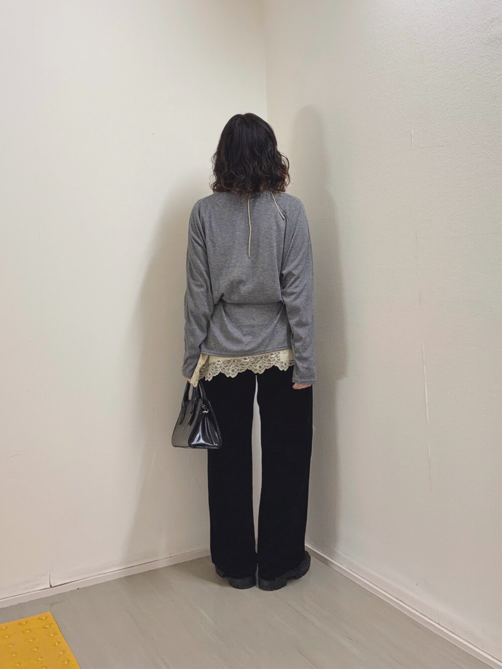 ベージュ系のキャミソール、ブラック系のデニムパンツ、ブラック系のボストンバッグを着用したレディースの冬コーディネートの4枚目の写真