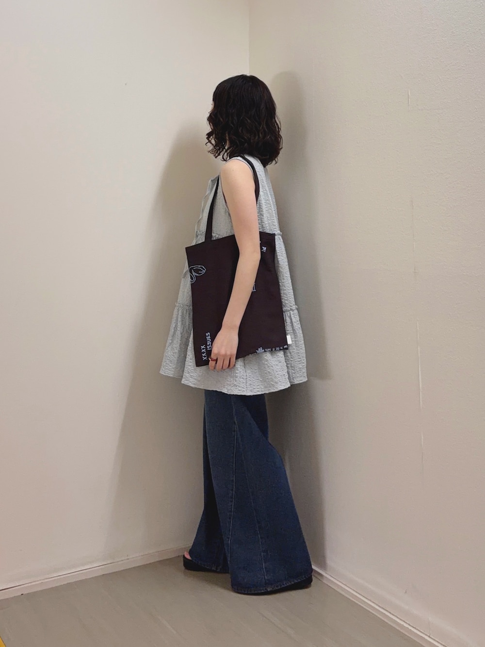 ブルー系のチュニック、ブルー系のデニムパンツ、ブラウン系のサンダルを着用したレディースの春コーディネートの2枚目の写真