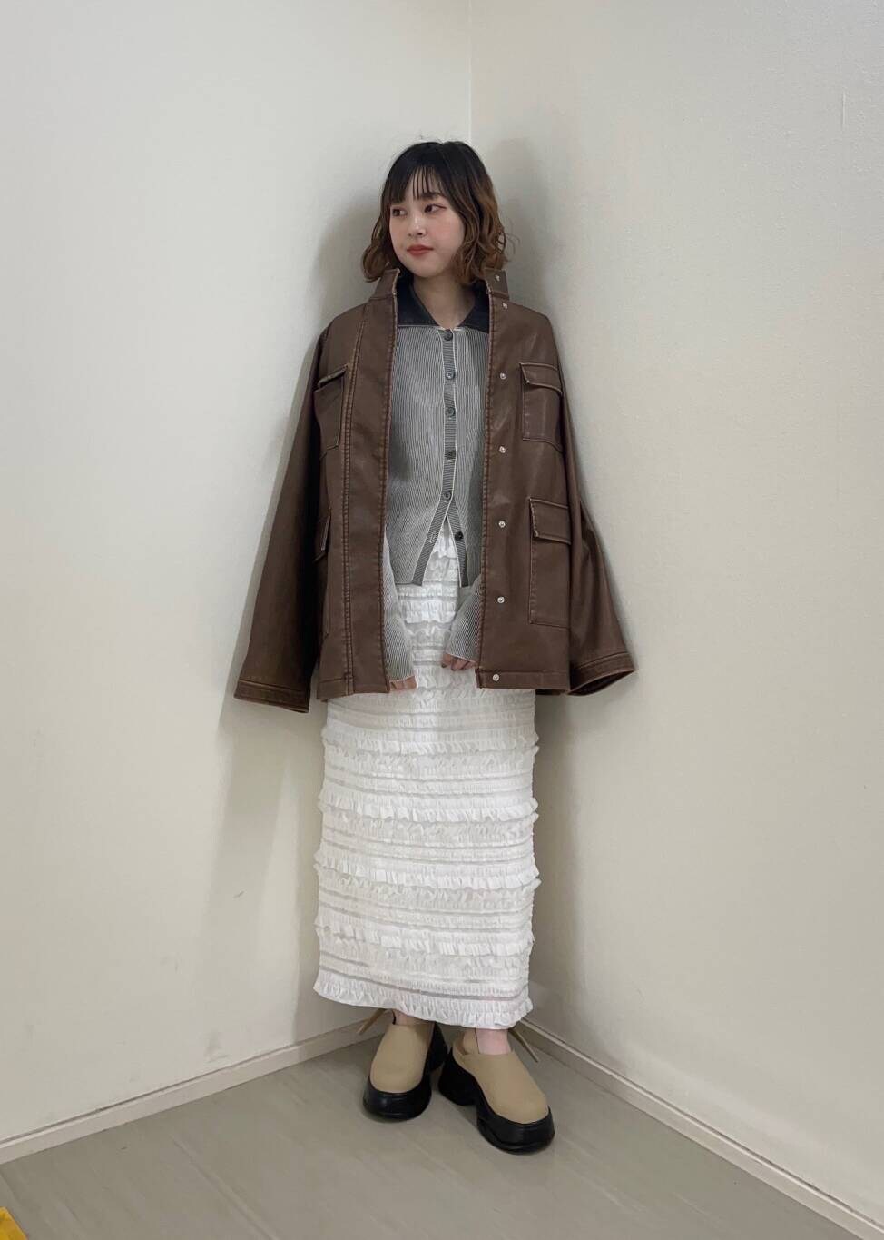 ホワイト系のニット/セーター、ベージュ系のサンダル、ホワイト系のスカートを着用したレディースの冬コーディネートの3枚目の写真