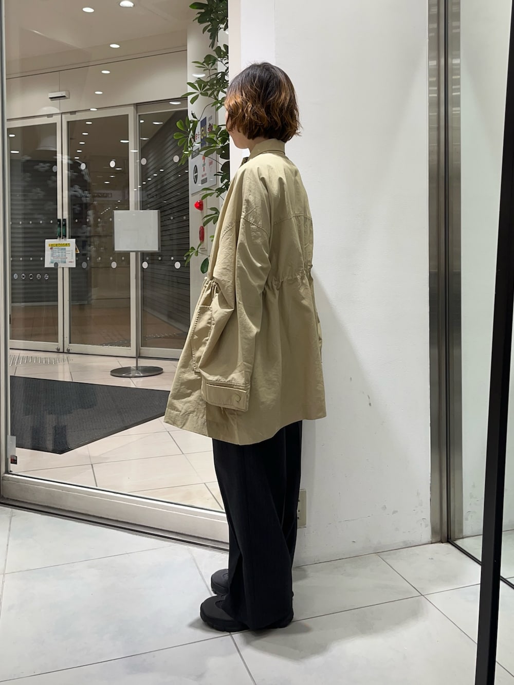 ベージュ系のナイロンジャケット、グレー系のその他パンツを着用したレディースの冬コーディネートの3枚目の写真