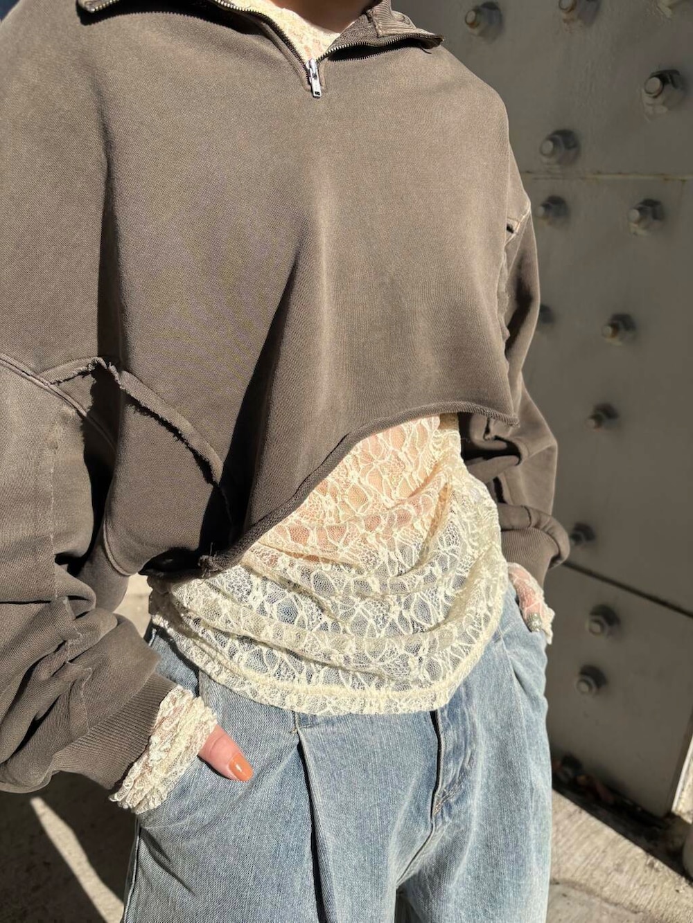 ブルー系のデニムパンツ、ベージュ系のサンダル、ブラウン系のスウェットを着用したレディースの冬コーディネートの2枚目の写真