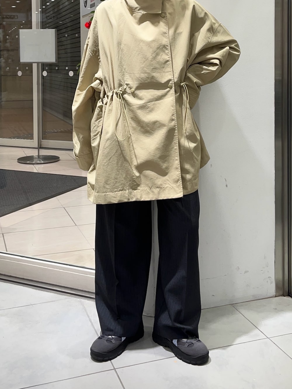 ベージュ系のナイロンジャケット、グレー系のその他パンツを着用したレディースの冬コーディネートの4枚目の写真