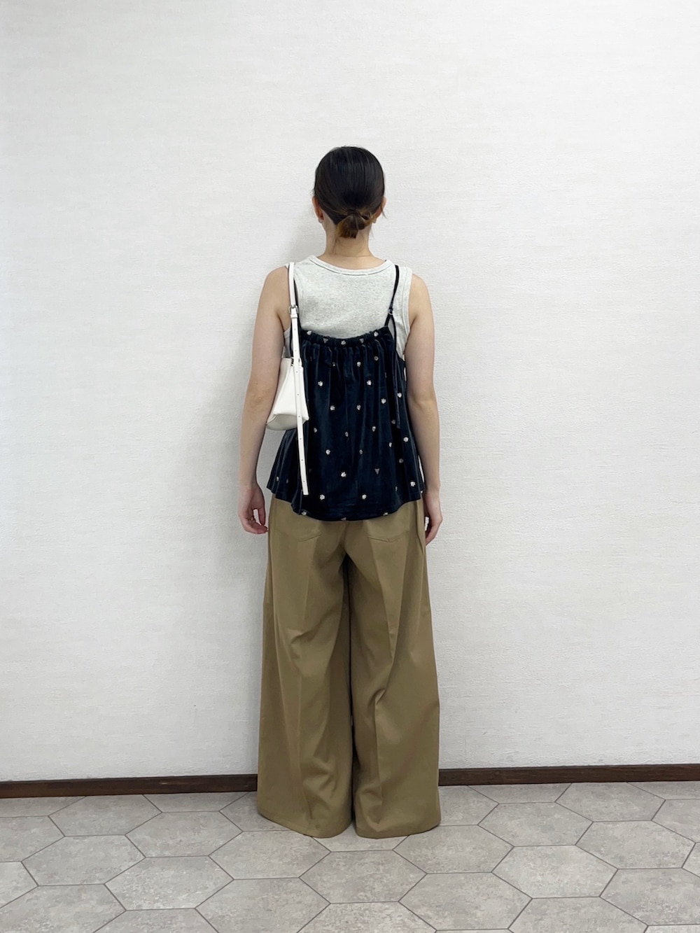 ベージュ系のタンクトップ、グレー系のキャミソール、ホワイト系のショルダーバッグを着用したレディースの秋コーディネートの4枚目の写真