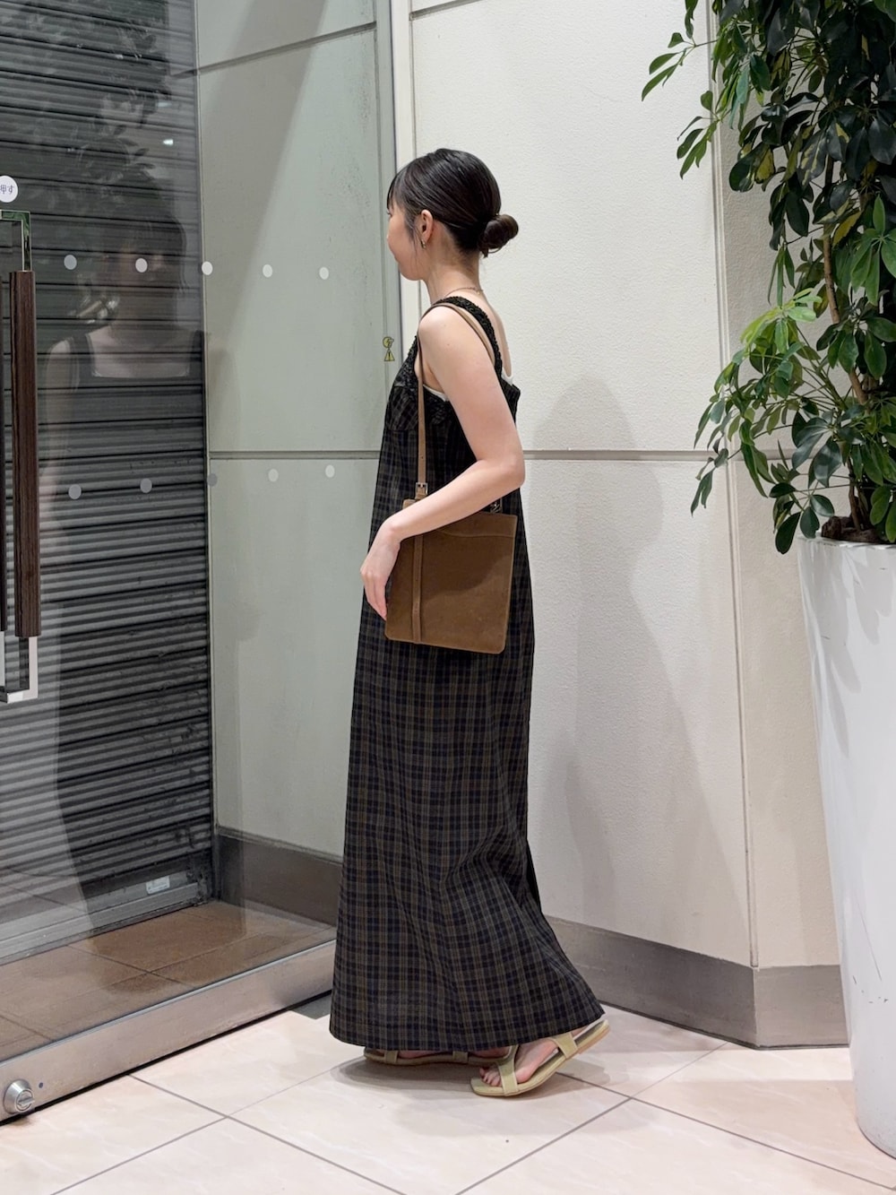 イエロー系のサンダル、イエロー系のショルダーバッグ、ブラック系のワンピースを着用したレディースの夏コーディネートの4枚目の写真