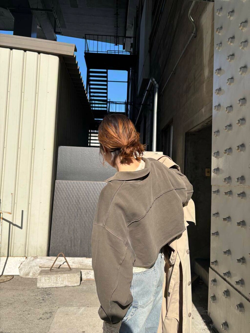 ブルー系のデニムパンツ、ベージュ系のサンダル、ブラウン系のスウェットを着用したレディースの冬コーディネートの4枚目の写真