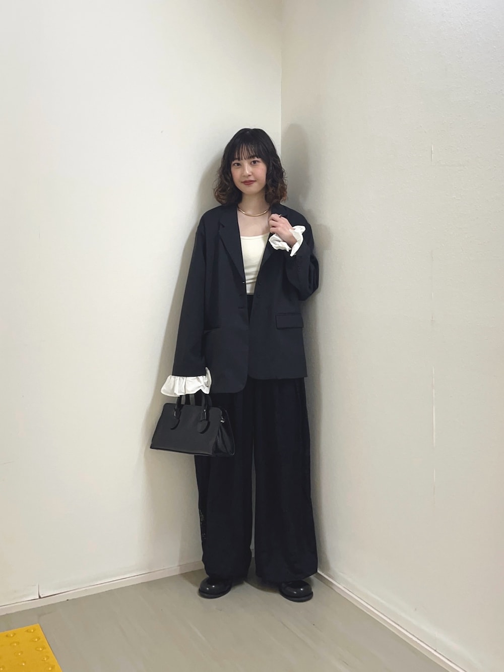 グレー系のその他アウター、ホワイト系のキャミソール、ブラック系のその他パンツを着用したレディースの冬コーディネートの2枚目の写真