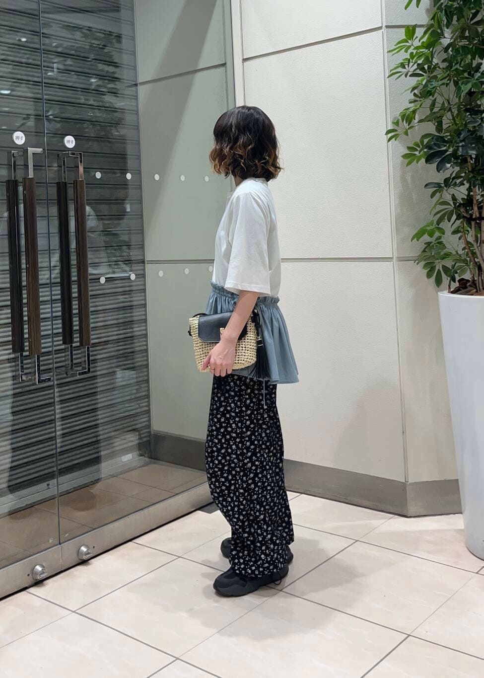 ベージュ系のショルダーバッグ、ブラック系のその他パンツ、ホワイト系のTシャツ/カットソーを着用したレディースの夏コーディネートの3枚目の写真