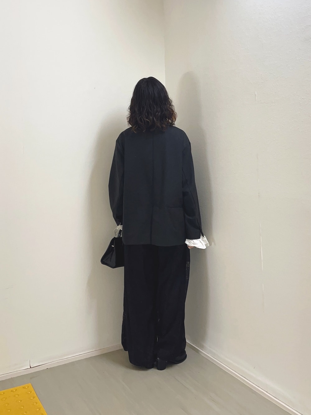 グレー系のその他アウター、ホワイト系のキャミソール、ブラック系のその他パンツを着用したレディースの冬コーディネートの4枚目の写真