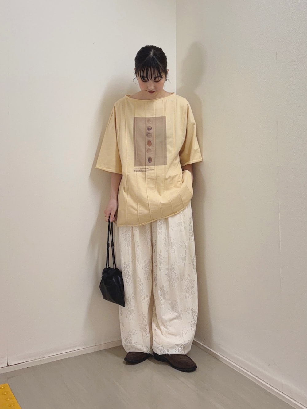 イエロー系のTシャツ/カットソー、ホワイト系のその他パンツ、ブラック系のショルダーバッグを着用したレディースの春コーディネートの2枚目の写真