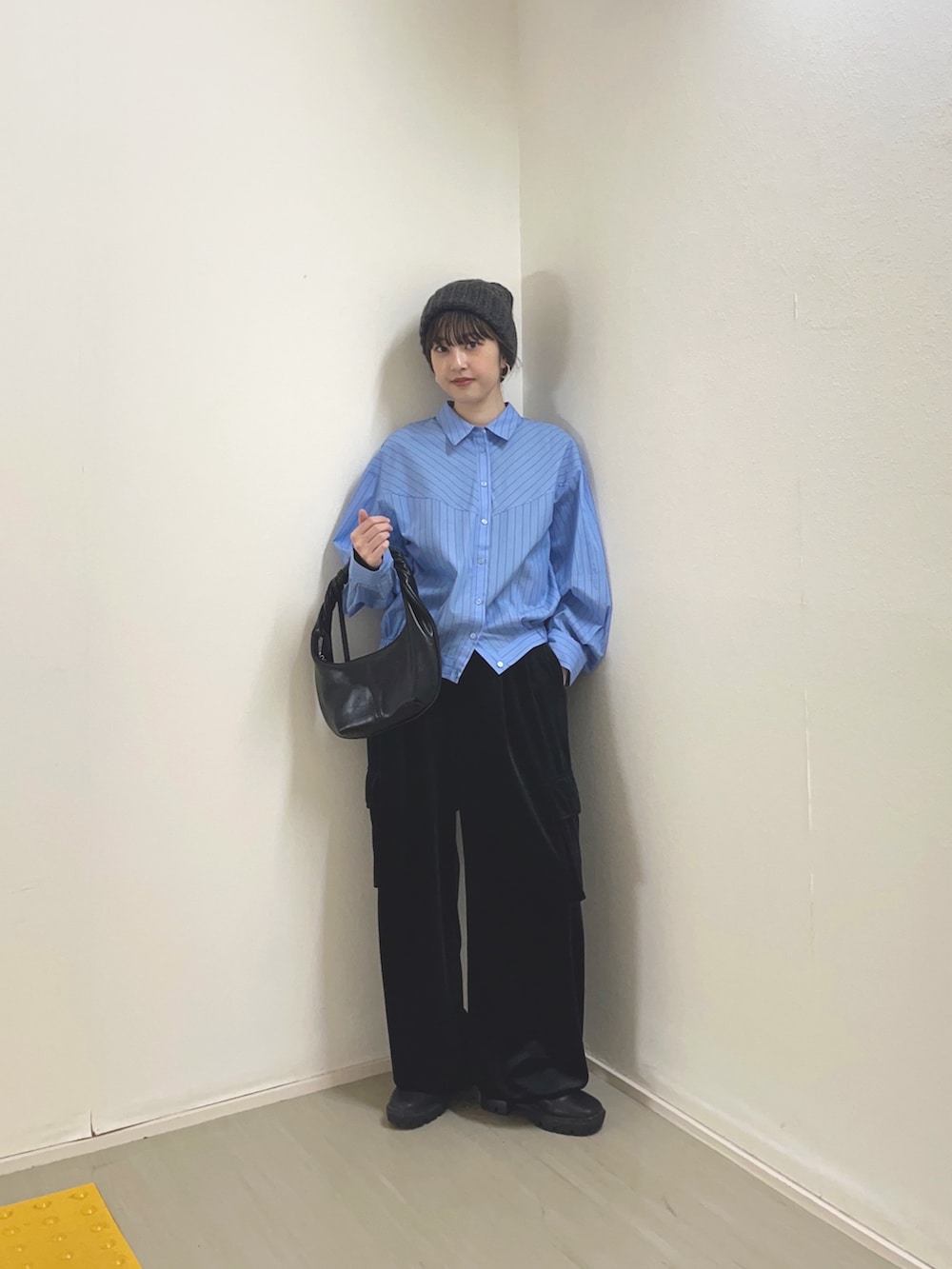 ブラック系のハンドバッグ、ブラウン系のブーツ、グレー系のシャツ/ブラウスを着用したレディースの冬コーディネートの2枚目の写真