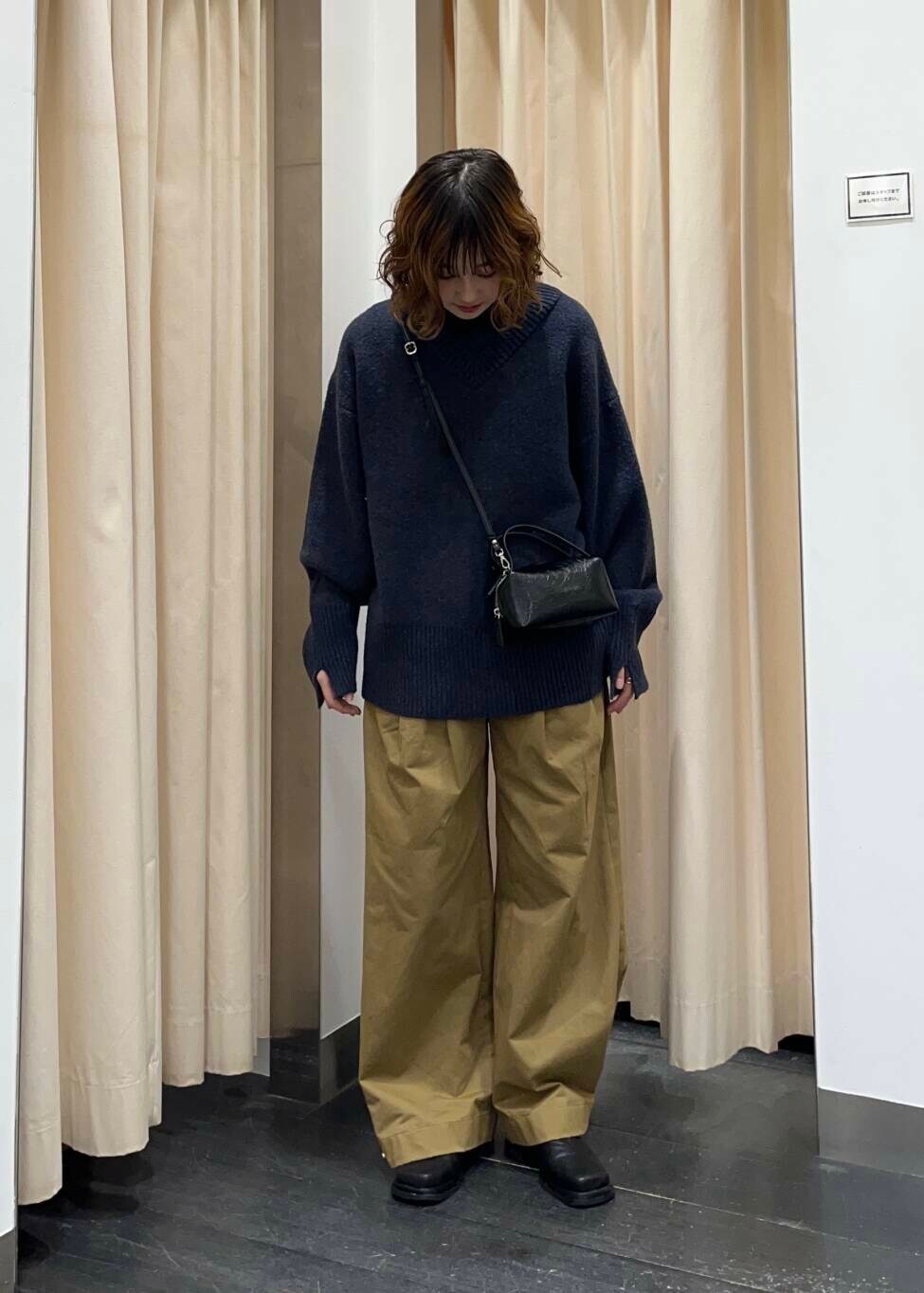 ブラック系のブーツ、ベージュ系のその他パンツ、ブルー系のニット/セーターを着用したレディースの秋コーディネートの2枚目の写真