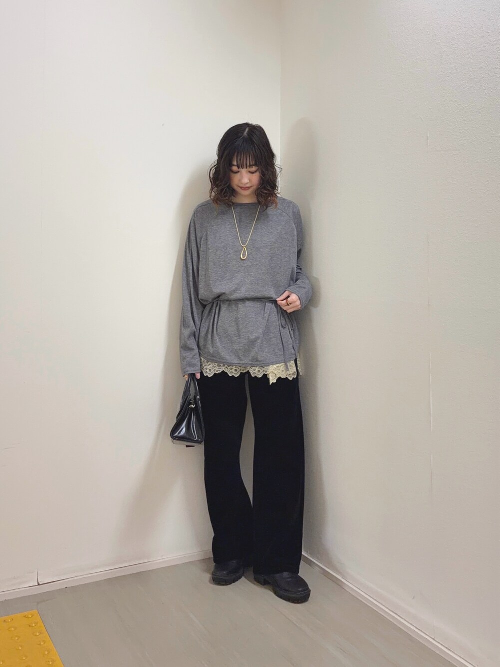 ベージュ系のキャミソール、ブラック系のデニムパンツ、ブラック系のボストンバッグを着用したレディースの冬コーディネートの2枚目の写真