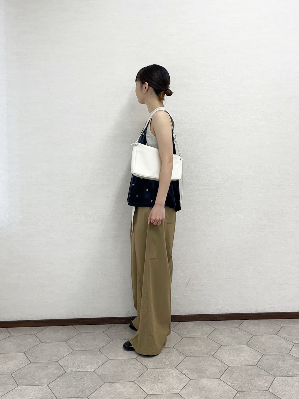 ベージュ系のタンクトップ、グレー系のキャミソール、ホワイト系のショルダーバッグを着用したレディースの秋コーディネートの3枚目の写真