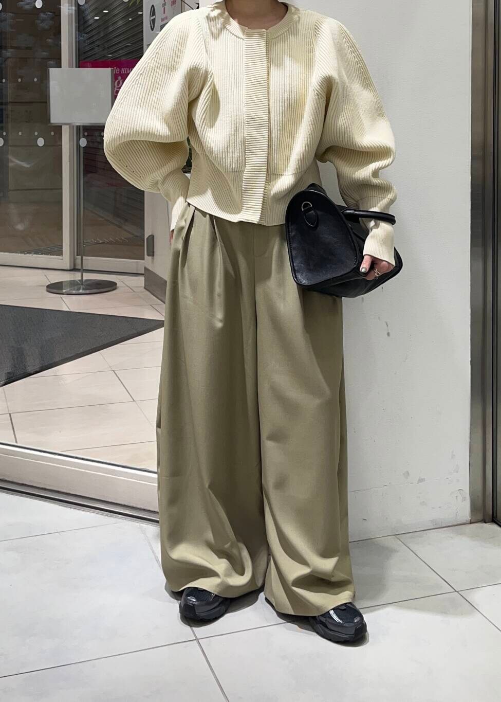 ブラック系のボストンバッグ、ベージュ系のその他パンツ、ホワイト系のカーディガン/ボレロを着用したレディースの冬コーディネートの4枚目の写真