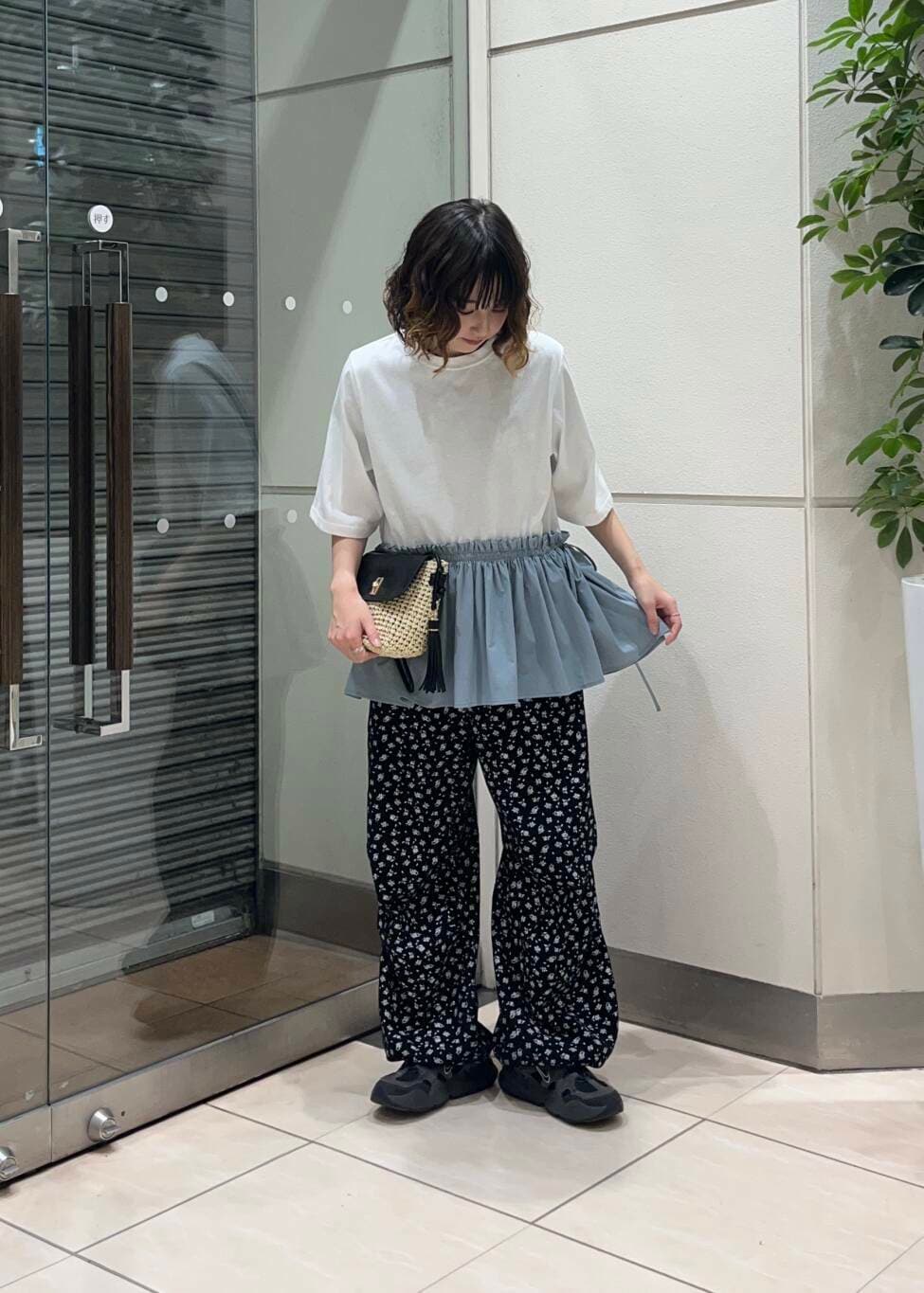 ベージュ系のショルダーバッグ、ブラック系のその他パンツ、ホワイト系のTシャツ/カットソーを着用したレディースの夏コーディネートの2枚目の写真