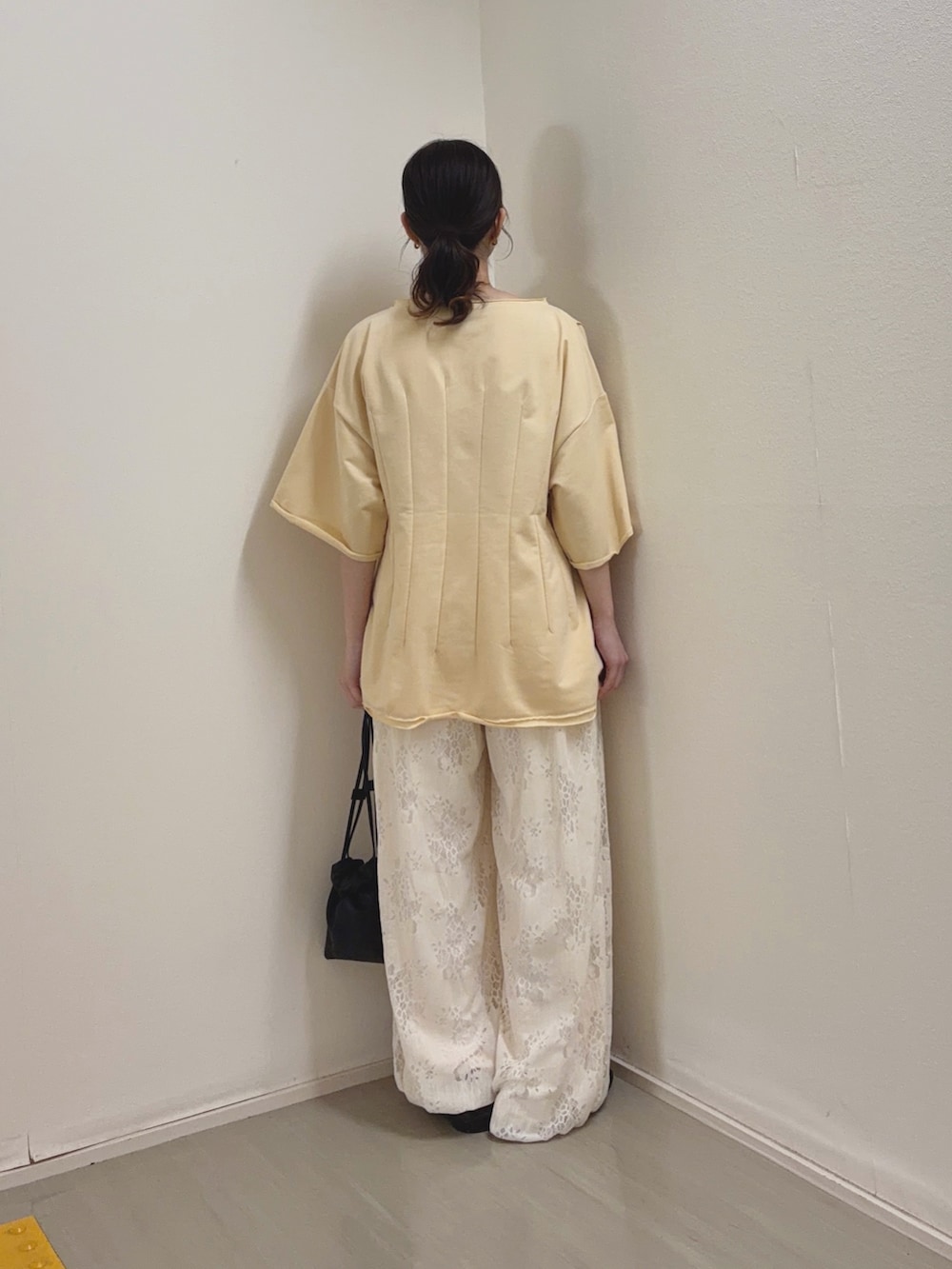 イエロー系のTシャツ/カットソー、ホワイト系のその他パンツ、ブラック系のショルダーバッグを着用したレディースの春コーディネートの4枚目の写真