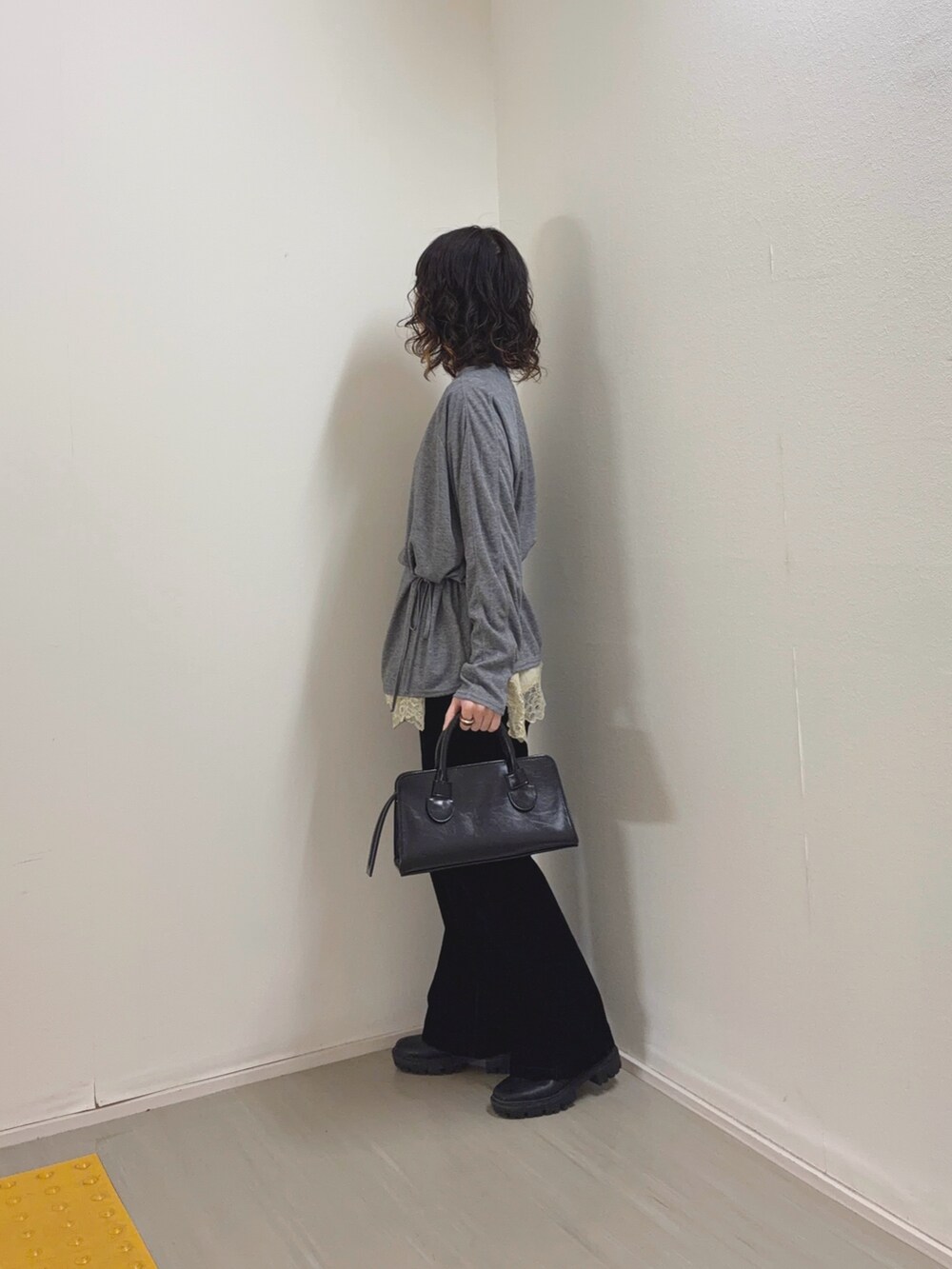 ベージュ系のキャミソール、ブラック系のデニムパンツ、ブラック系のボストンバッグを着用したレディースの冬コーディネートの3枚目の写真