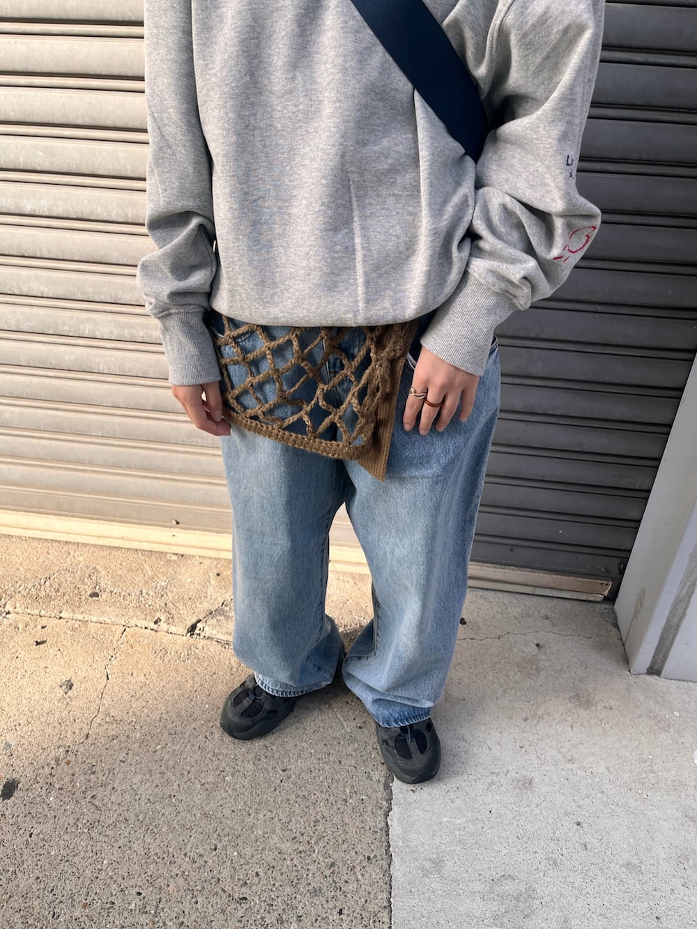 ブルー系のデニムパンツ、ブルー系のショルダーバッグ、グレー系のスウェットを着用したレディースの秋コーディネートの4枚目の写真