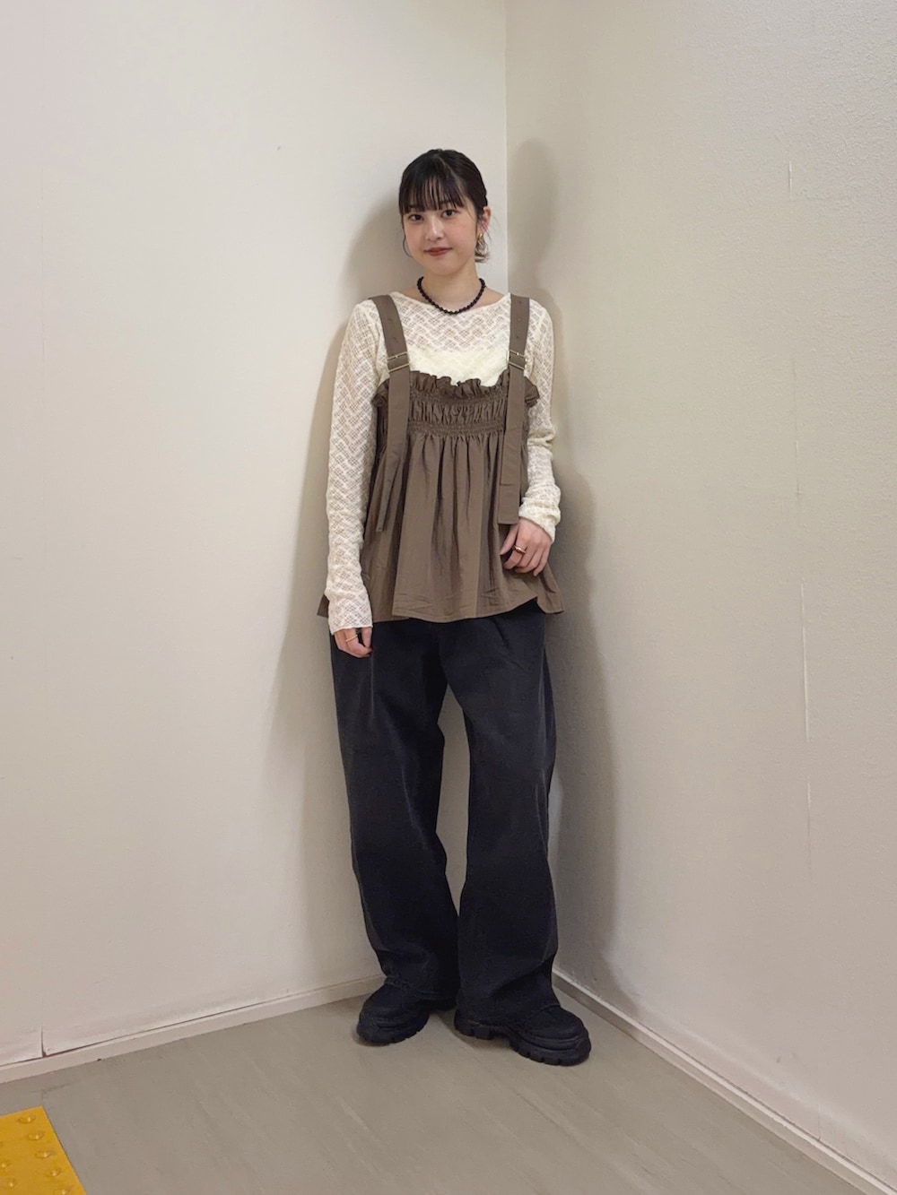 ブラック系のデニムパンツ、ブラック系のスニーカー、ホワイト系のTシャツ/カットソーを着用したレディースの春コーディネートの2枚目の写真