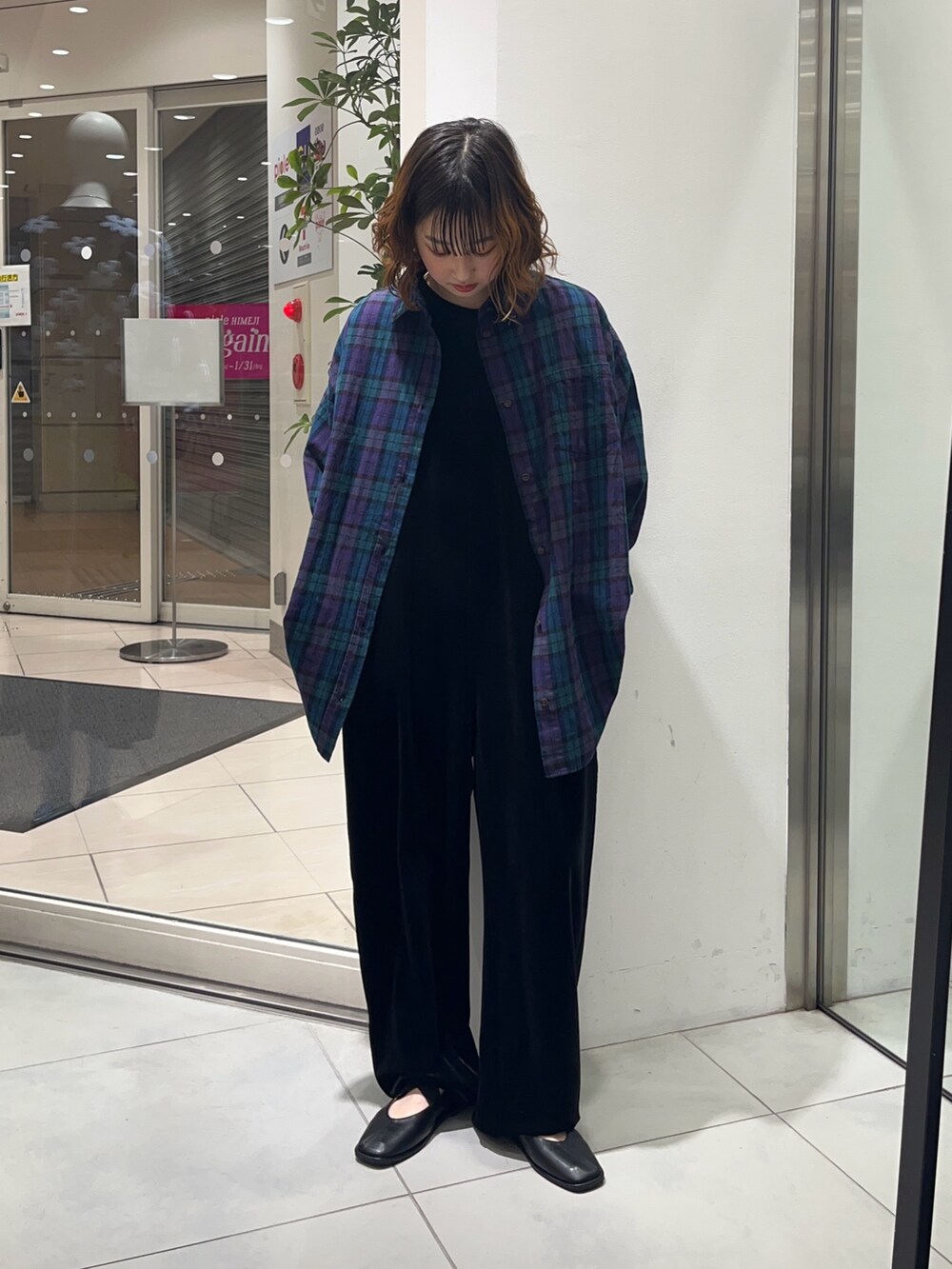 グリーン系のシャツ/ブラウス、ブラック系のサロペット/オーバーオール、ブラック系のバレエシューズを着用したレディースの冬コーディネートの2枚目の写真