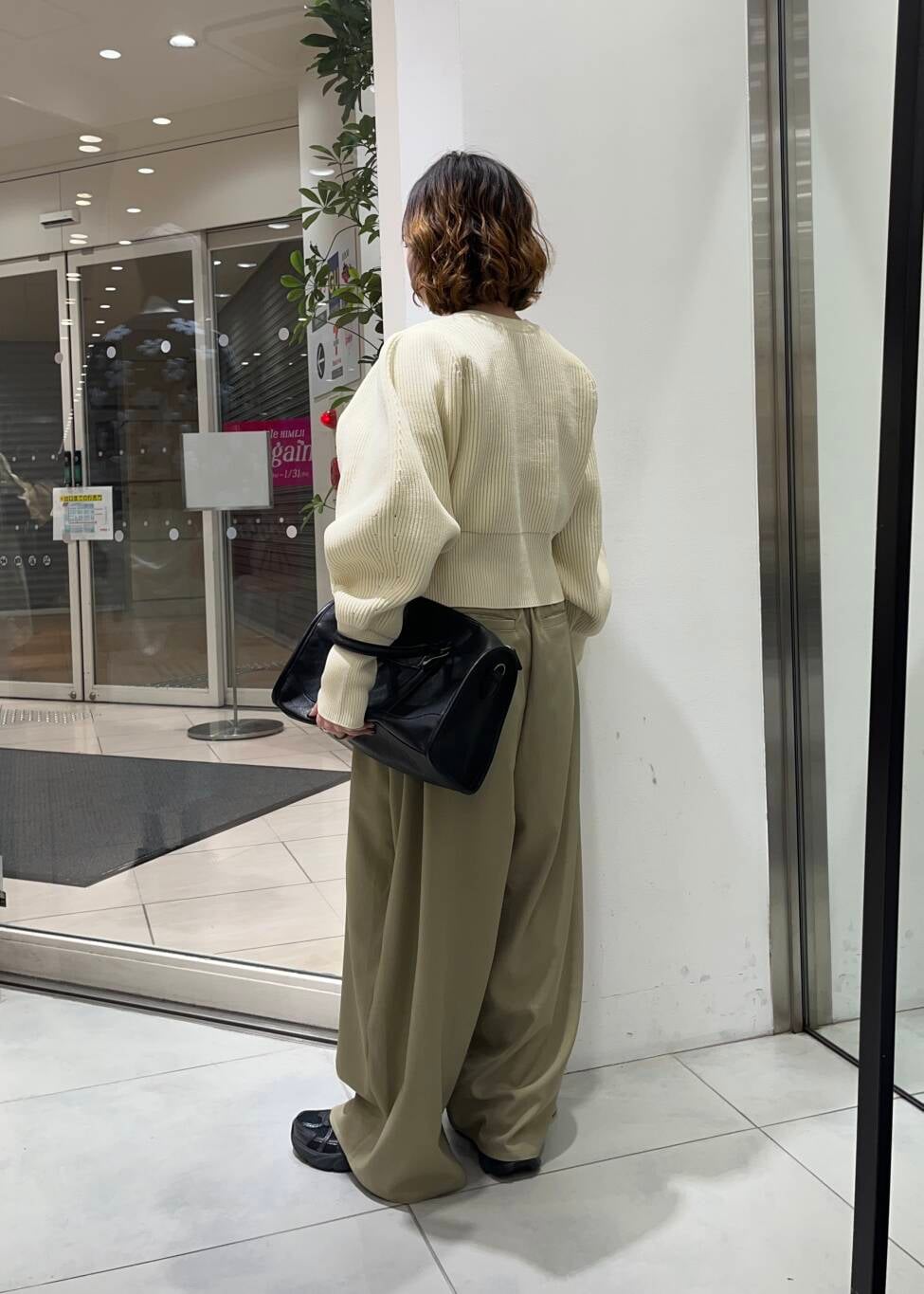 ブラック系のボストンバッグ、ベージュ系のその他パンツ、ホワイト系のカーディガン/ボレロを着用したレディースの冬コーディネートの3枚目の写真