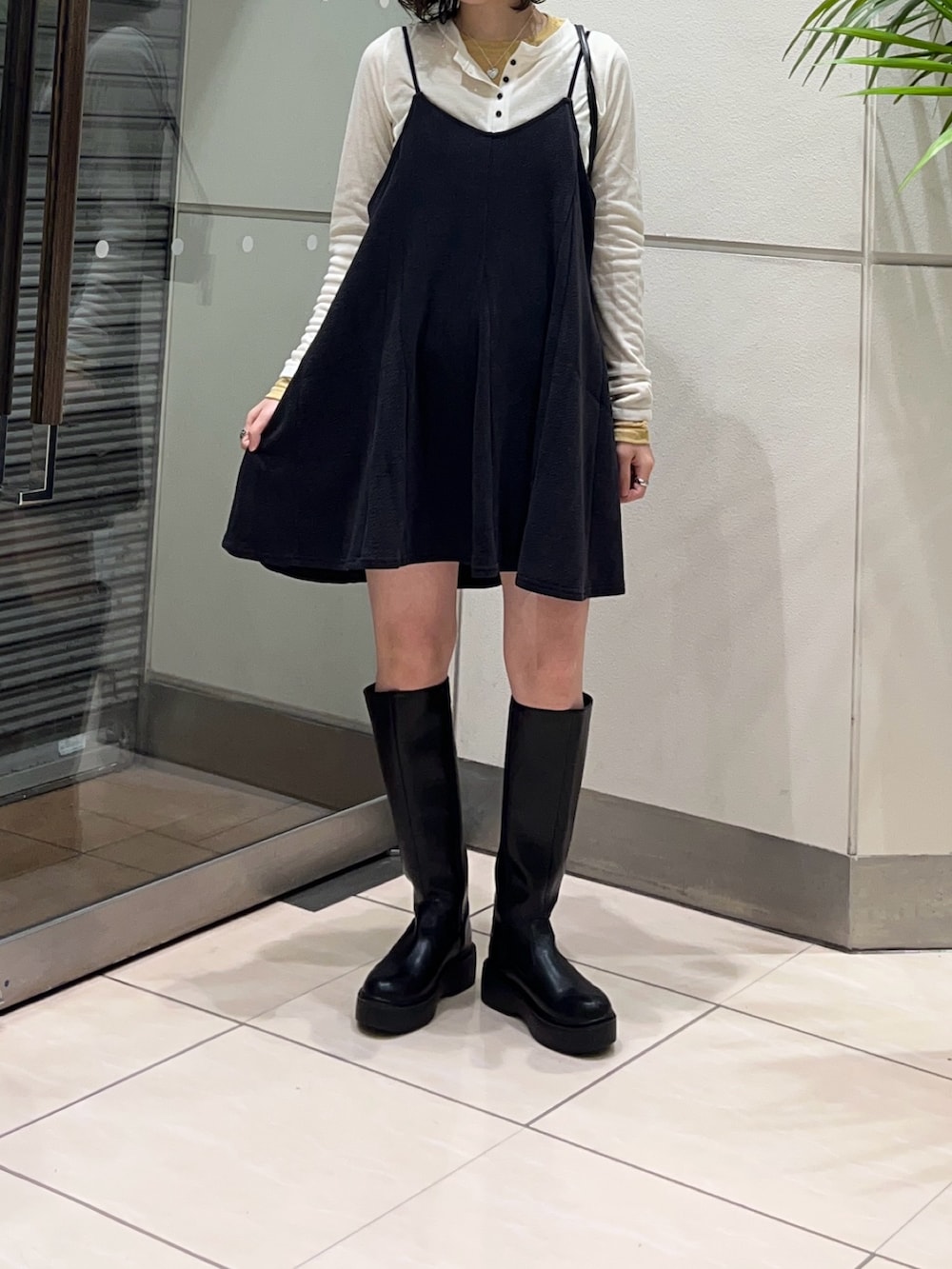 ブラック系のブーツ、グレー系のワンピース、ブラック系のショルダーバッグを着用したレディースの秋コーディネートの5枚目の写真