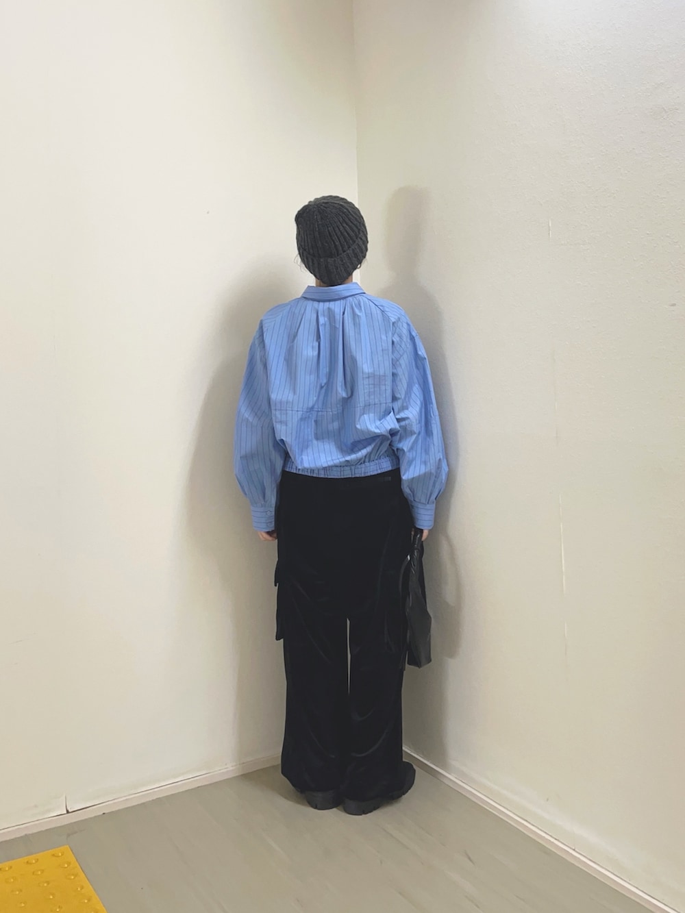 ブラック系のハンドバッグ、ブラウン系のブーツ、グレー系のシャツ/ブラウスを着用したレディースの冬コーディネートの4枚目の写真