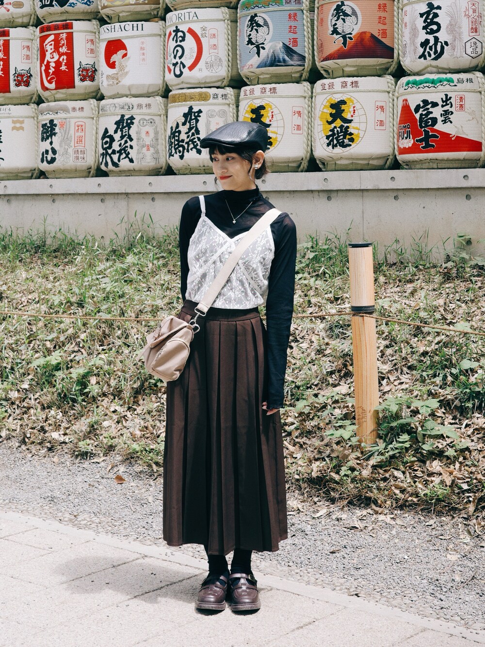 ブラック系のトップス、ホワイト系のキャミソール、ブラウン系のローファーを着用したレディースの春コーディネートの2枚目の写真