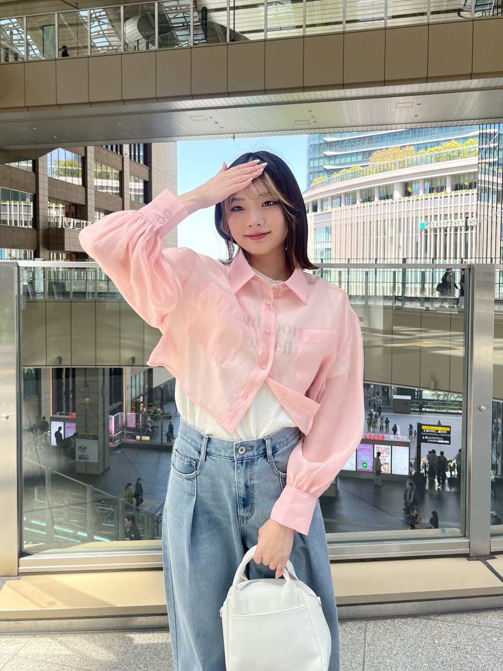 ピンク系のシャツ/ブラウス、ホワイト系のTシャツ/カットソー、ブルー系のデニムパンツを着用したレディースの春コーディネートの3枚目の写真