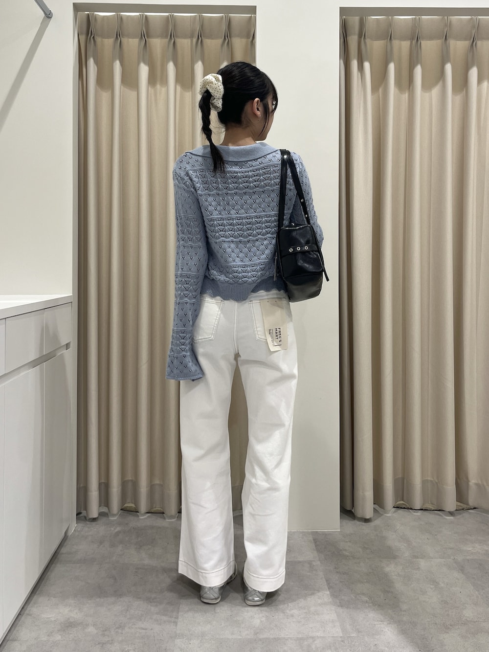 ブルー系のニット/セーター、ホワイト系のデニムパンツを着用したレディースの春コーディネートの3枚目の写真