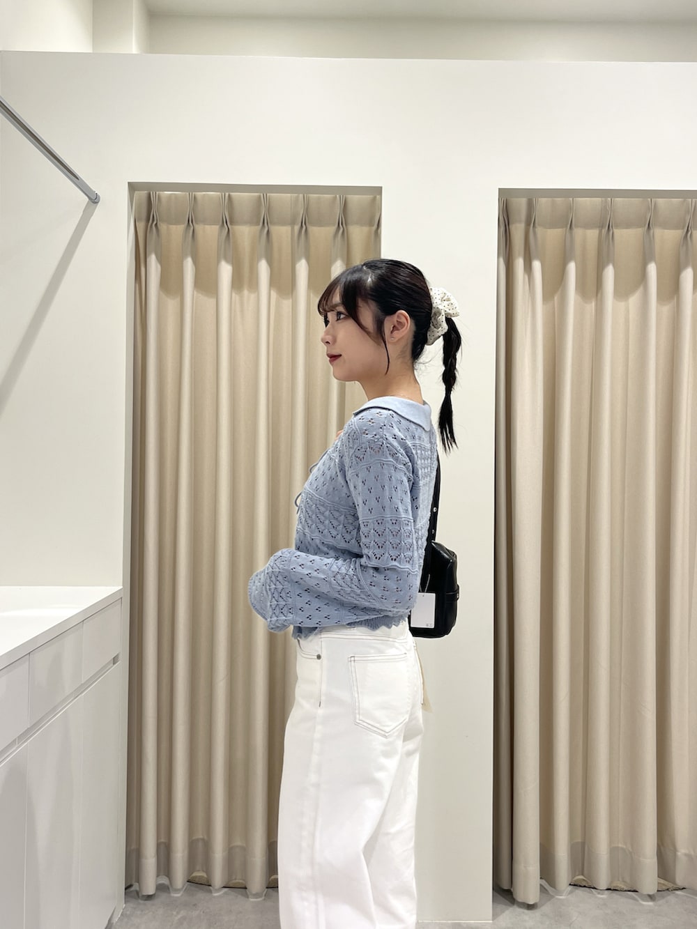 ブルー系のニット/セーター、ホワイト系のデニムパンツを着用したレディースの春コーディネートの5枚目の写真