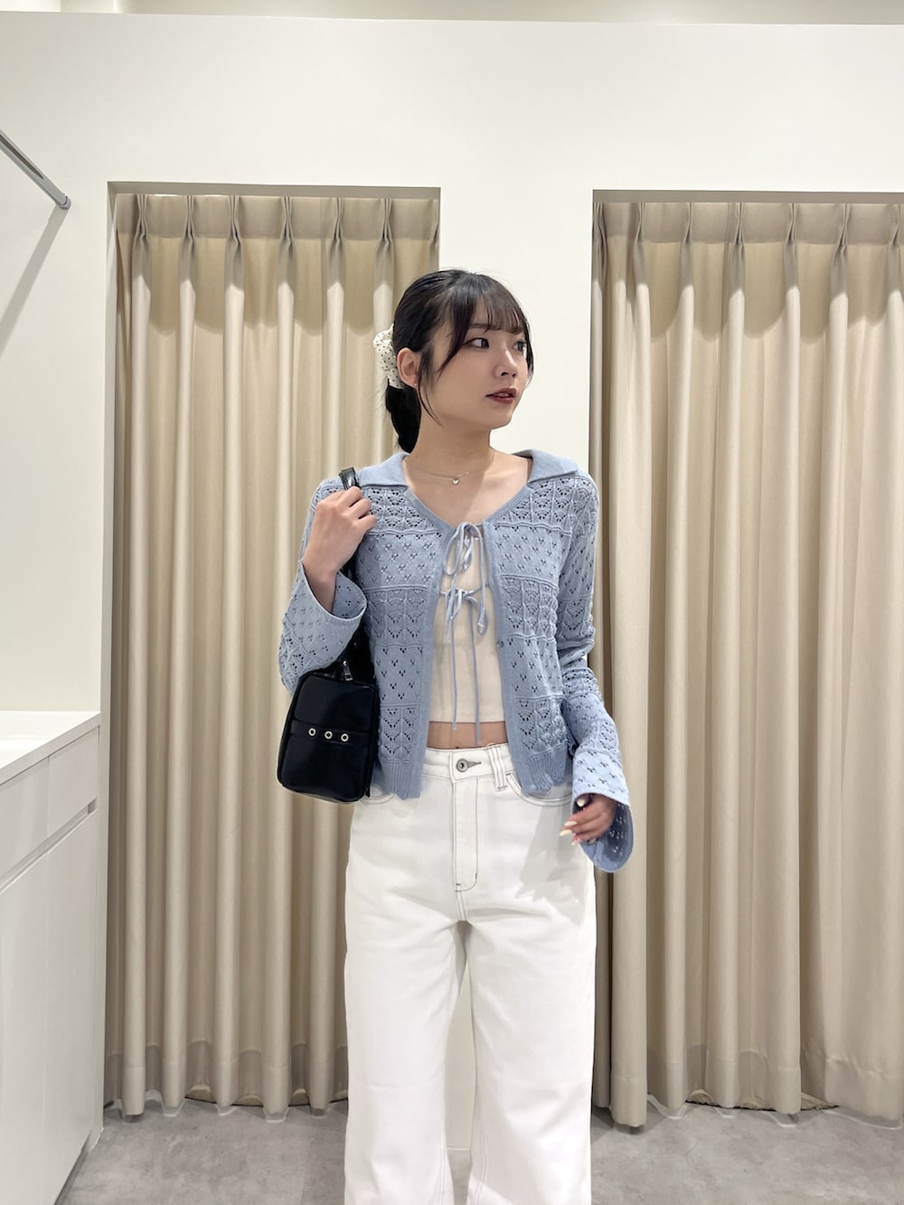 ブルー系のニット/セーター、ホワイト系のデニムパンツを着用したレディースの春コーディネートの4枚目の写真