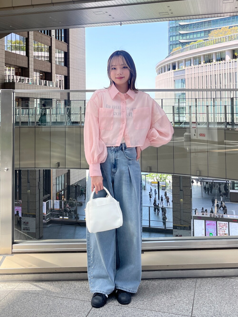 ピンク系のシャツ/ブラウス、ホワイト系のTシャツ/カットソー、ブルー系のデニムパンツを着用したレディースの春コーディネートの2枚目の写真