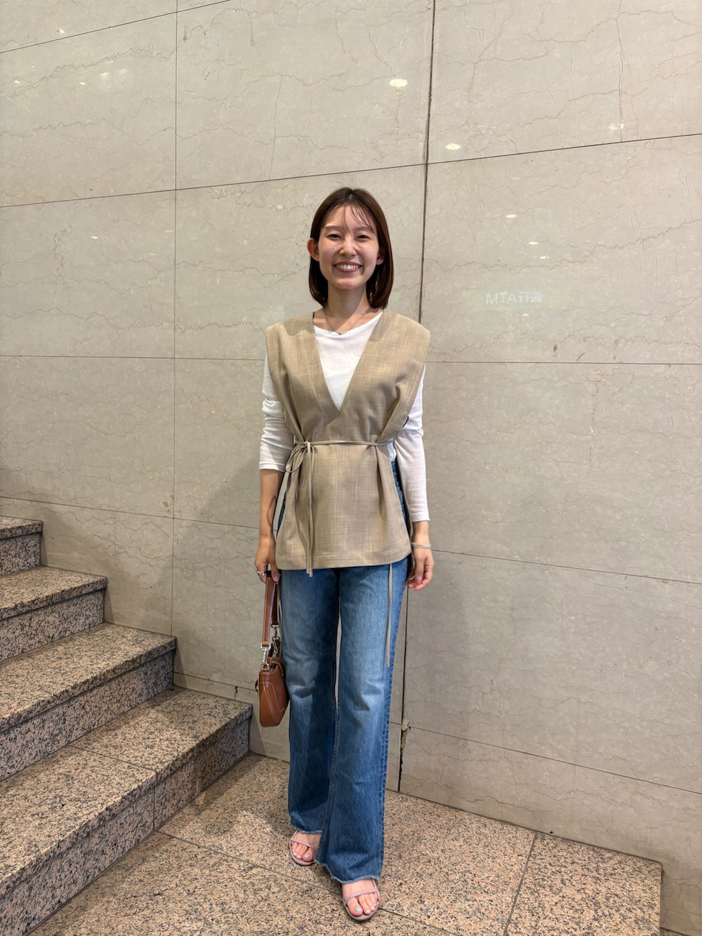 ベージュ系のシャツ/ブラウス、ホワイト系のTシャツ/カットソー、ブラウン系のハンドバッグを着用したレディースの夏コーディネートの2枚目の写真