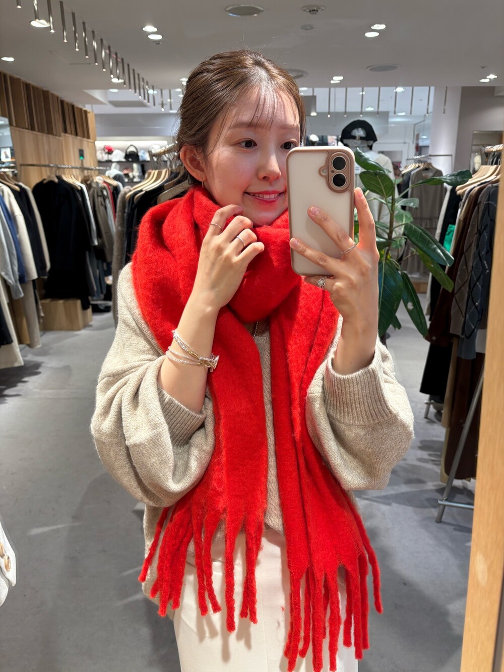 ベージュ系のニット/セーター、ホワイト系のスカート、レッド系のマフラーを着用したレディースの冬コーディネートの3枚目の写真