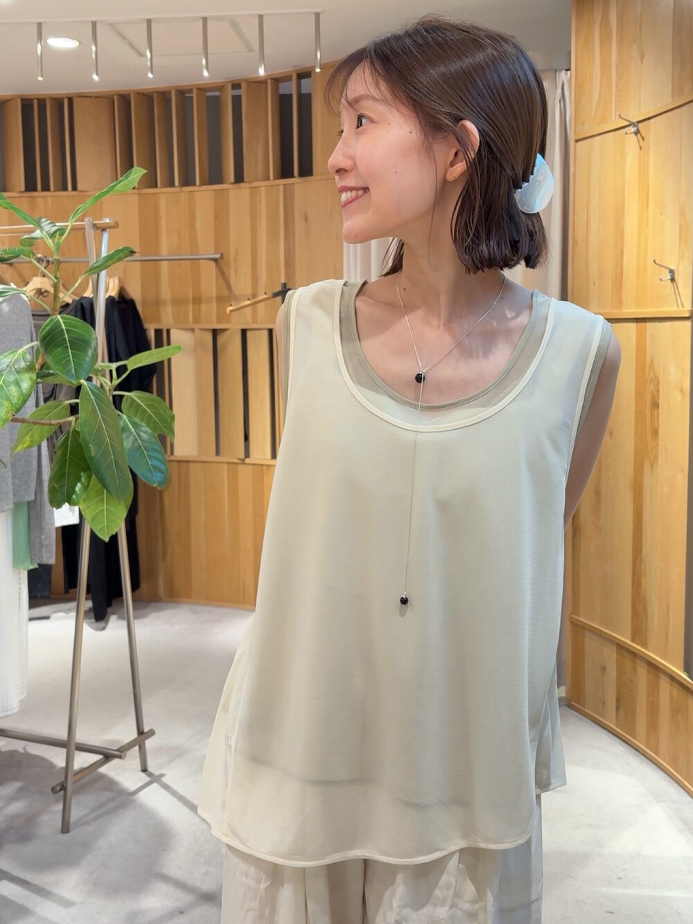 ホワイト系のタンクトップ、ホワイト系のその他パンツ、ブラウン系のハンドバッグを着用したレディースの夏コーディネートの3枚目の写真