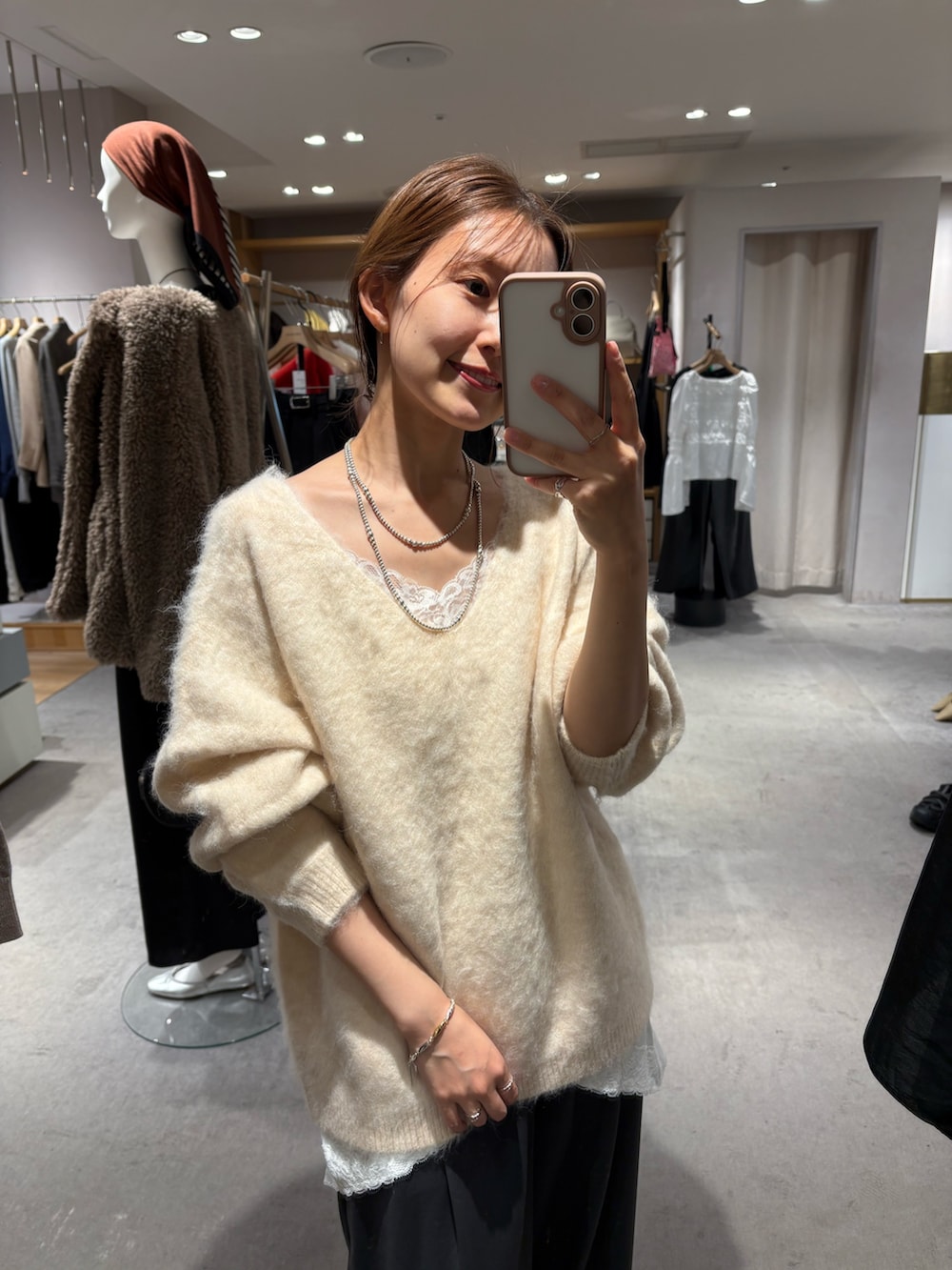 ホワイト系のニット/セーター、ホワイト系のキャミソール、グレー系のスラックスを着用したレディースの秋コーディネートの2枚目の写真