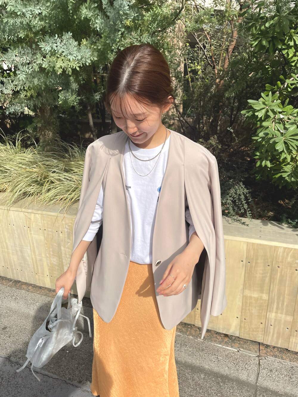 ホワイト系のTシャツ/カットソー、シルバー系のショルダーバッグ、オレンジ系のスカートを着用したレディースの冬コーディネートの4枚目の写真