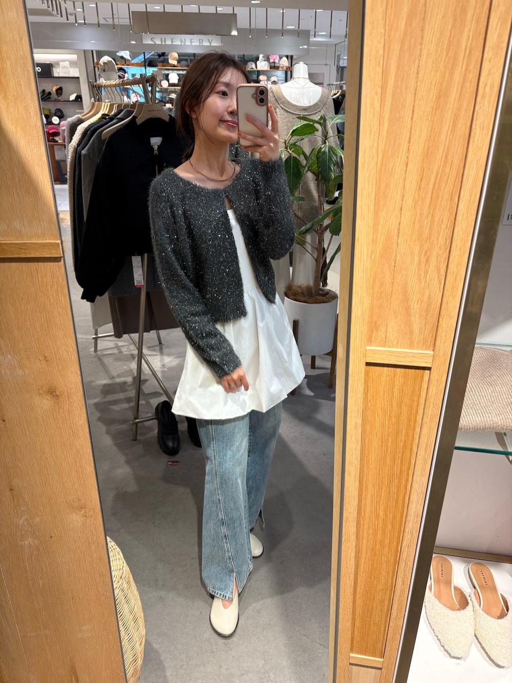 グレー系のカーディガン/ボレロ、ホワイト系のキャミソール、ブルー系のデニムパンツを着用したレディースの冬コーディネートの2枚目の写真