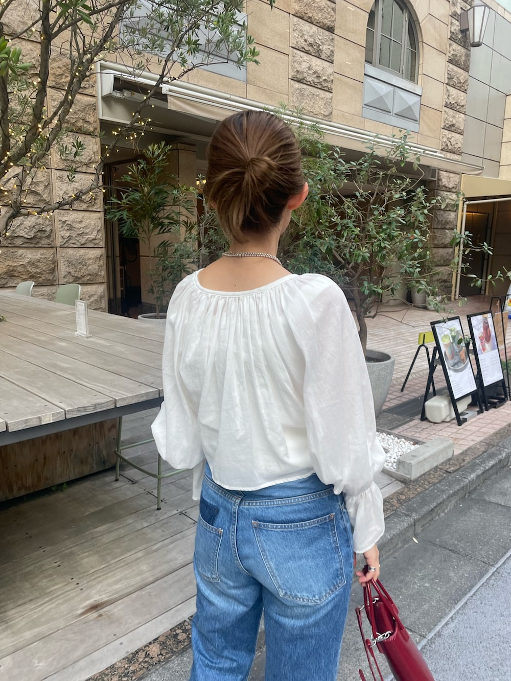 ホワイト系のシャツ/ブラウス、ブルー系のデニムパンツ、ホワイト系のキャミソールを着用したレディースの秋コーディネートの2枚目の写真